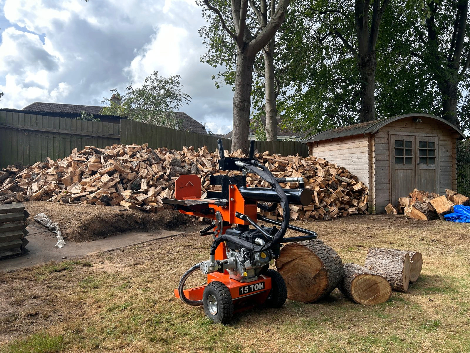 Large pile of freshly split seasoned hardwood firewood beside Gildergreen's log splitter in Bedfordshire
